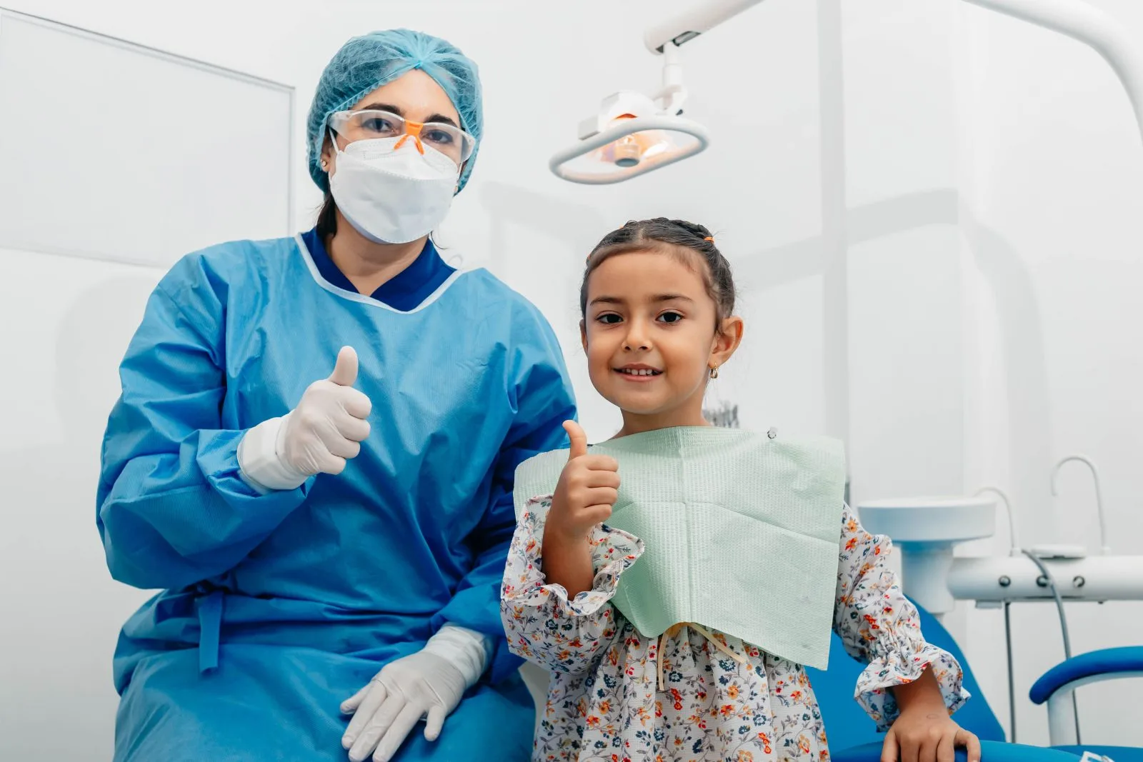Dentist and young patient giving a thumbs up after a checkup